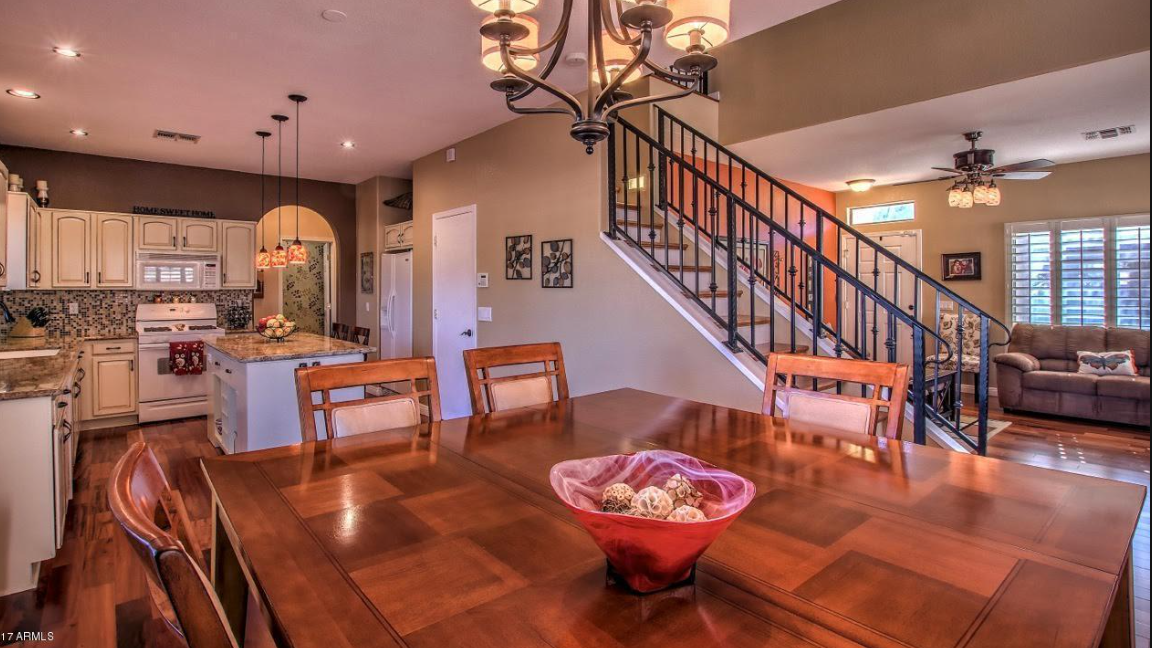 Open staircase with iron railing overlooking the kitchen and dining area of an older Arizona home