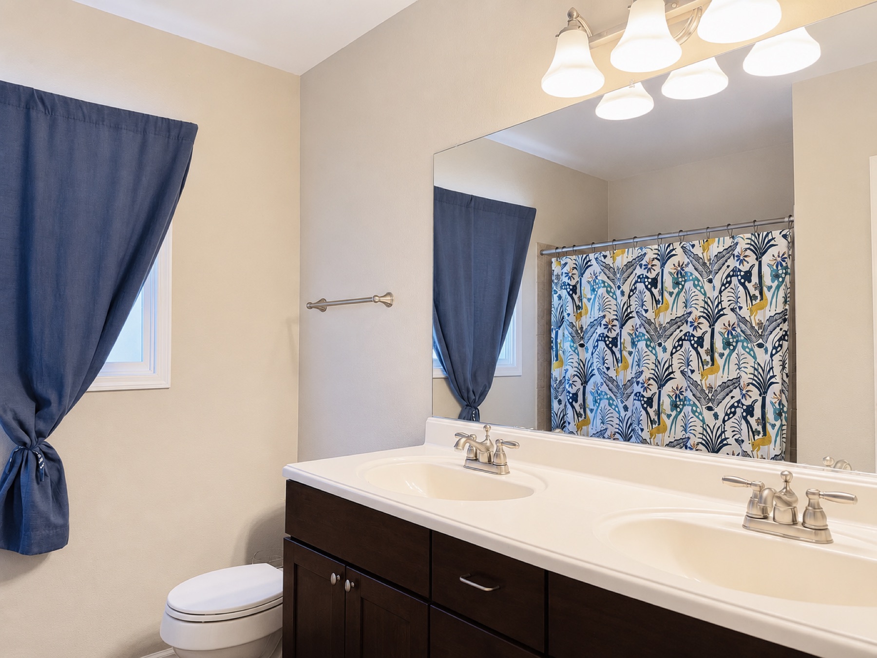 Original hall bathroom before the remodel with a dark double vanity, laminate counter, and a shower curtain