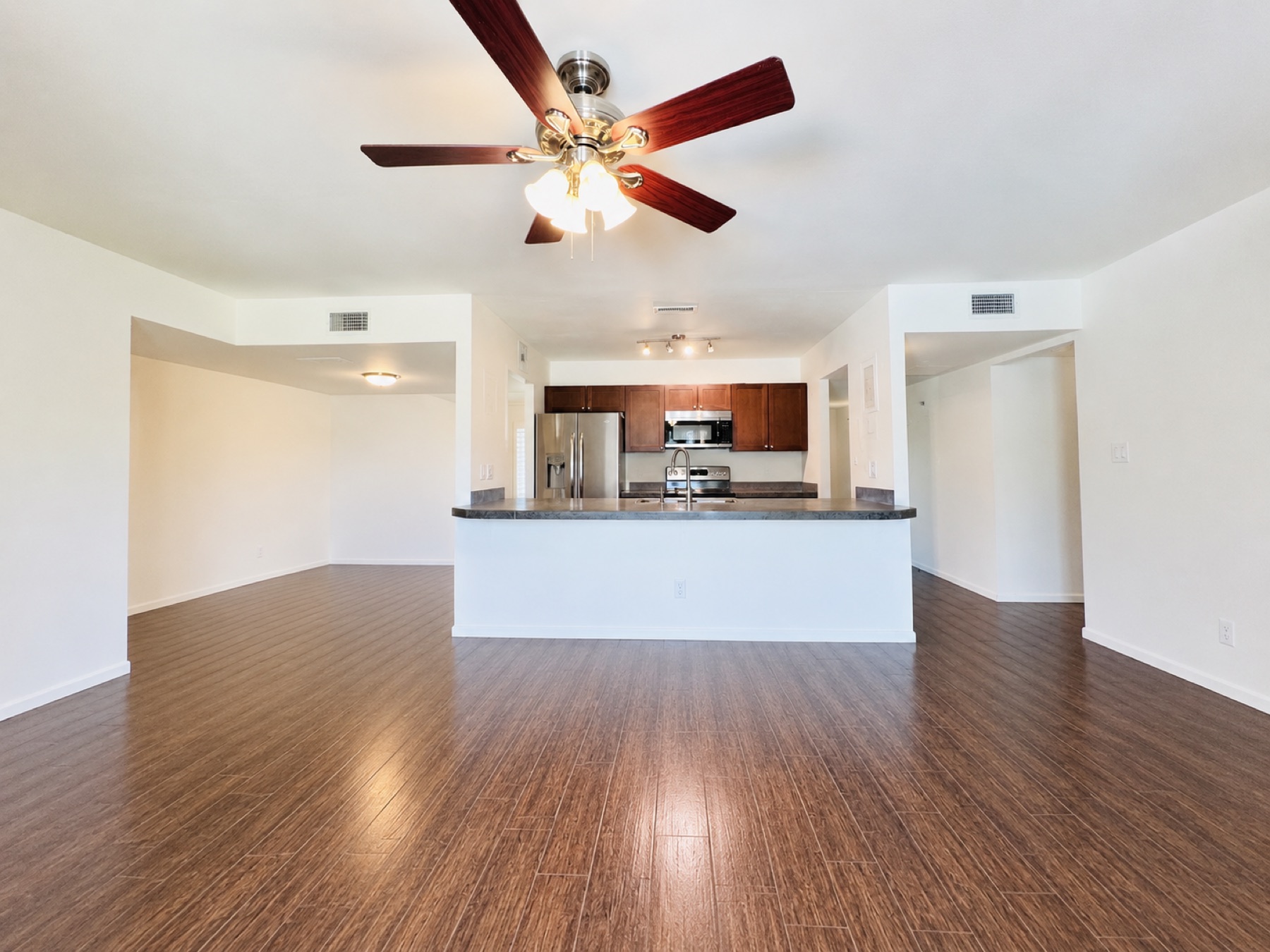 Original kitchen before the remodel, sitting in the center of the house with dark cabinets and a peninsula counter