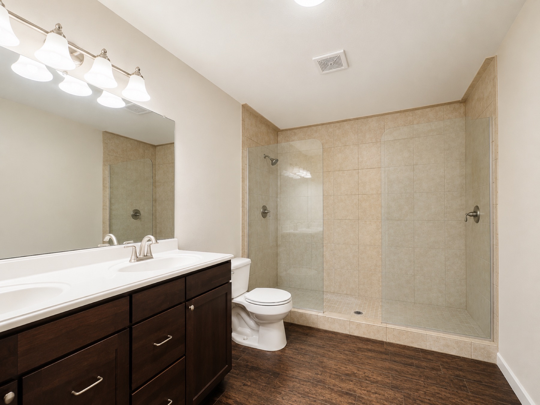 Original primary bathroom before the remodel with a dark vanity, laminate countertop, and beige tile shower