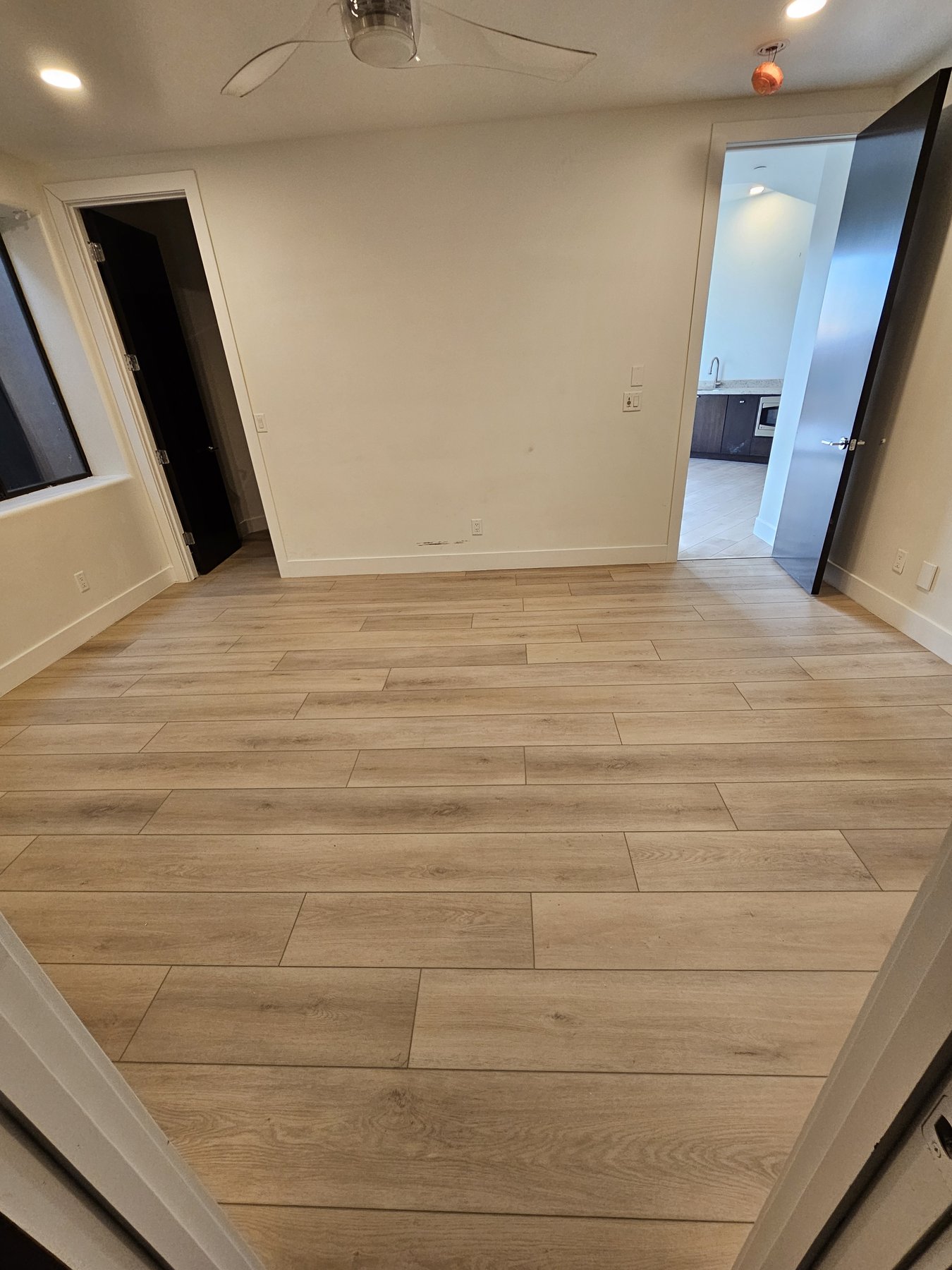New flooring running from a living area into the kitchen