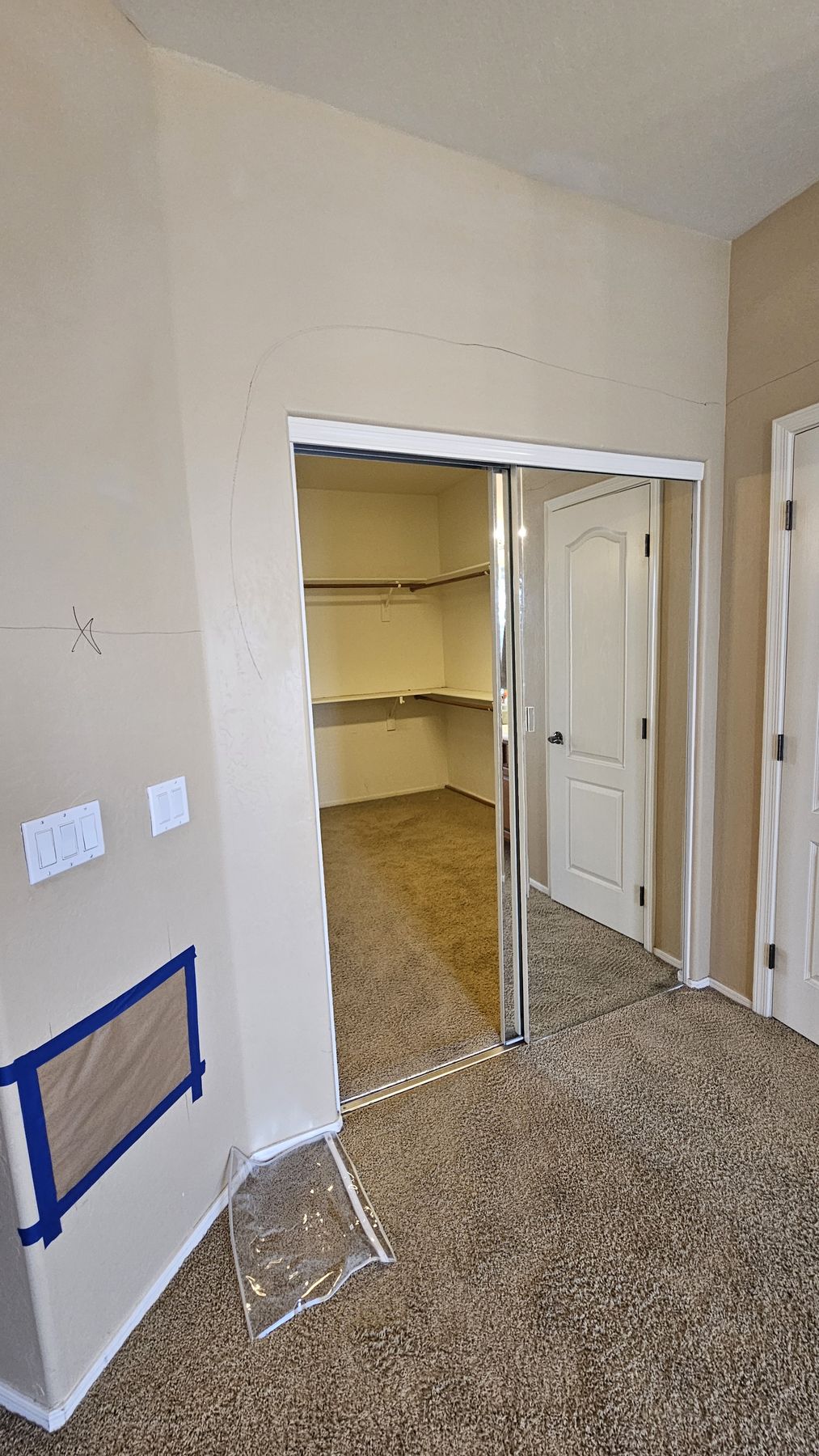 Original mirrored closet doors before the remodel, in the hallway leading to the primary closet