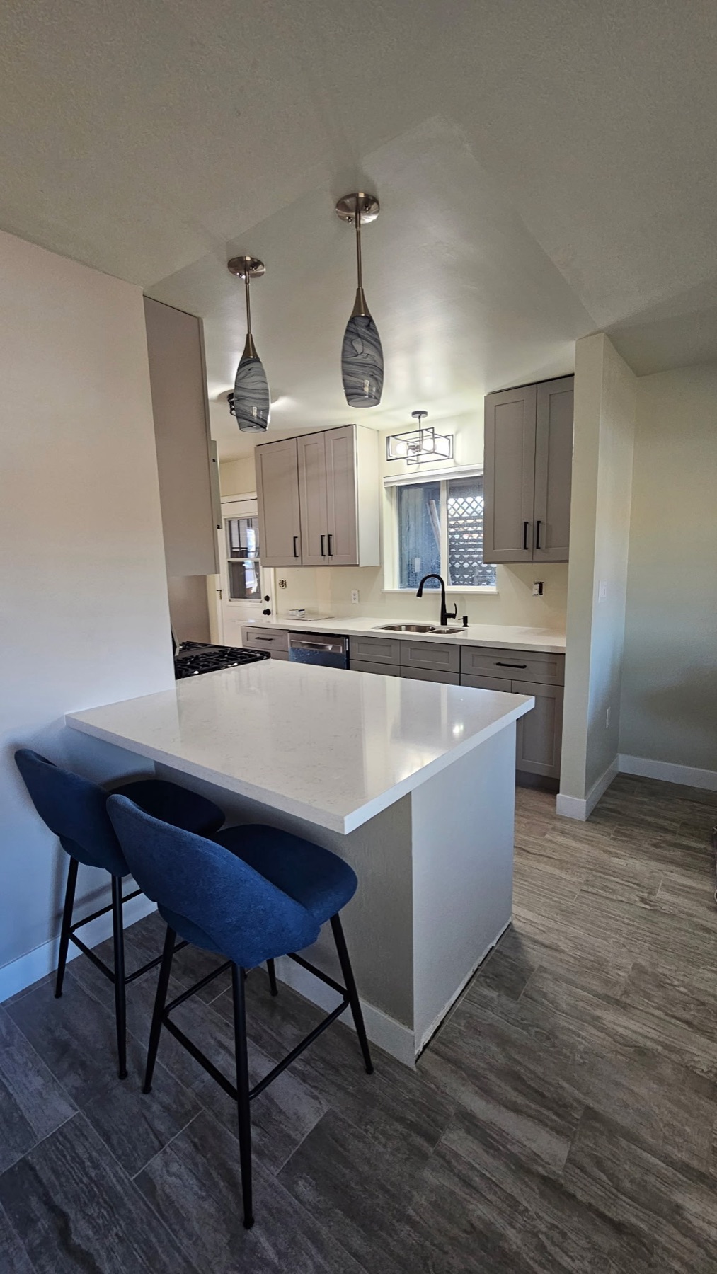 Finished kitchen remodel showing the full scope — cabinets, counters, and finishes
