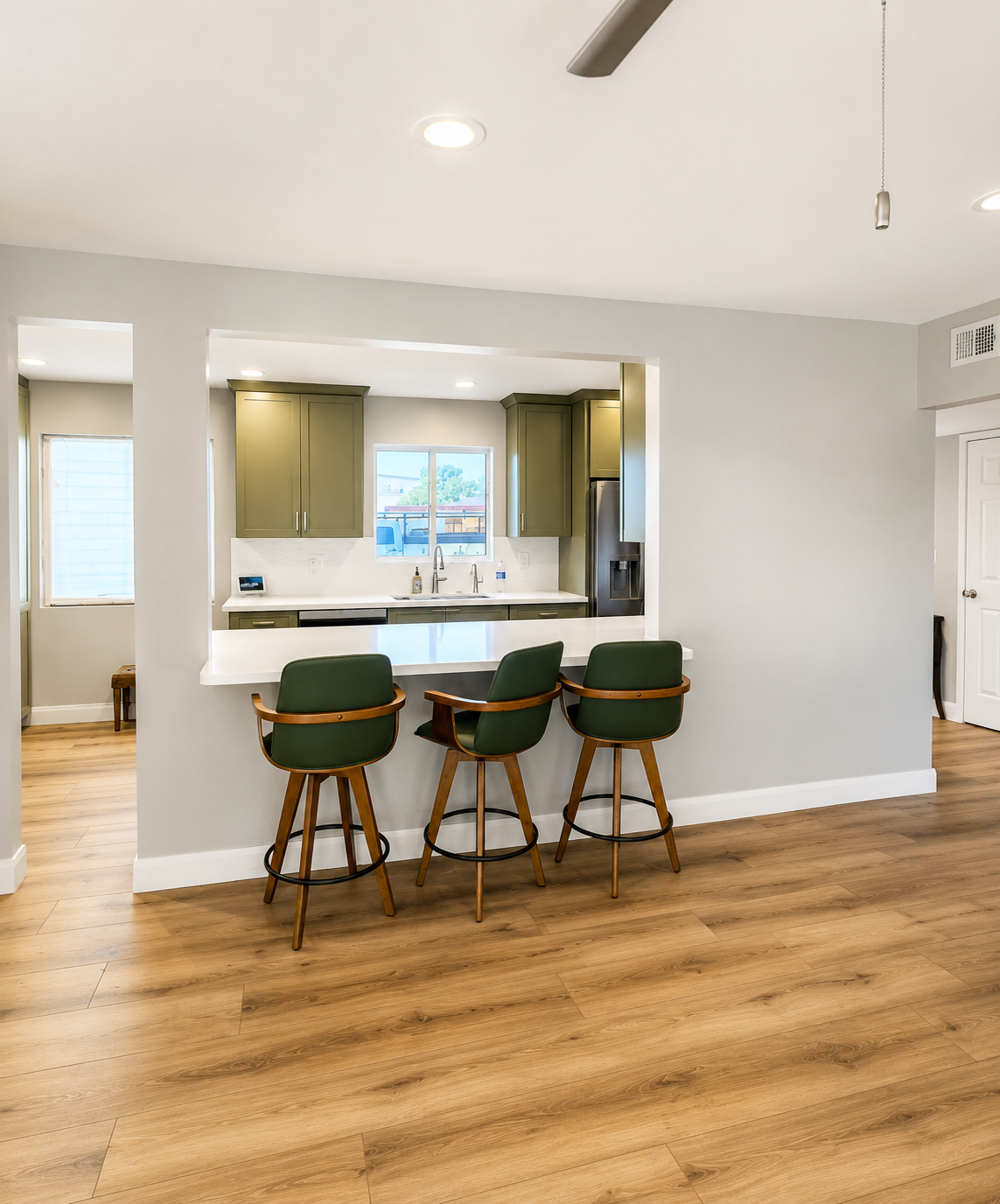Remodeled Scottsdale kitchen opened into the living room with a new bar-height seating counter and three stools