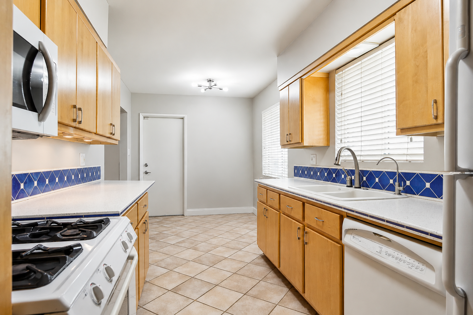 Original kitchen layout with oak cabinets and a gas range before the remodel